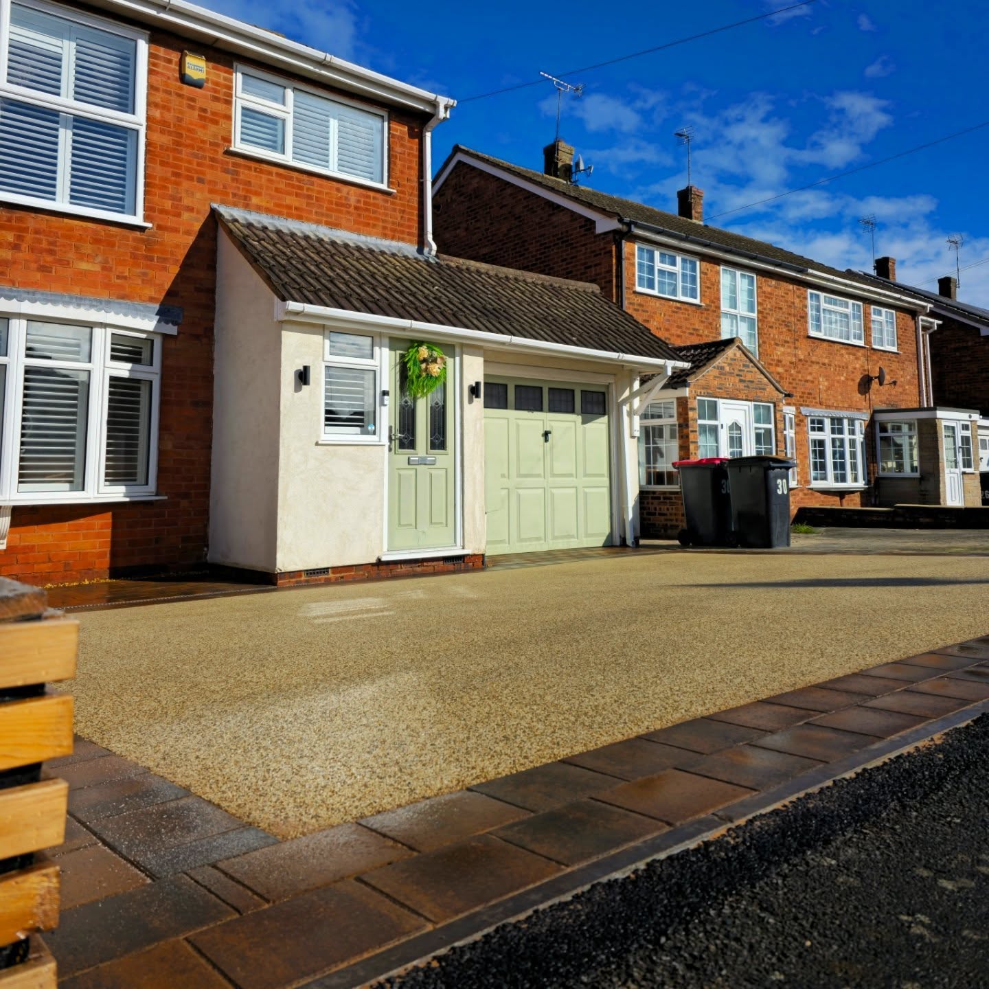 Finished resin driveway with a double block border in front of a house
